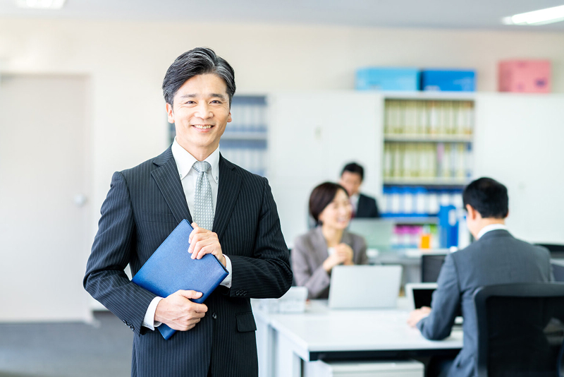 オフィスで査定額を持つスーツ男性